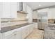 Kitchen area featuring granite countertops, stainless steel hood, and modern appliances at 12286 Regal Lily Ln, Orlando, FL 32827
