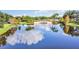 Picturesque view of a pond reflecting the sky, framed by trees and a charming pedestrian bridge at 12286 Regal Lily Ln, Orlando, FL 32827