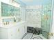 This bright and modern bathroom has white cabinets and fixtures with marble accent walls at 12406 Beacontree Way, Orlando, FL 32837