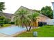 Home exterior featuring a blue driveway and palm trees, providing a touch of tropical ambiance at 12406 Beacontree Way, Orlando, FL 32837