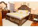 This bedroom features a dark wood carved bed frame with an ornate headboard and matching furniture at 12406 Beacontree Way, Orlando, FL 32837