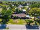 Scenic aerial view of a charming home with a well-manicured lawn and lush trees, near a lake at 1250 Tangerine Ct, Eustis, FL 32726