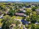 Scenic aerial view of a charming home with a well-manicured lawn and lush trees, near a lake at 1250 Tangerine Ct, Eustis, FL 32726
