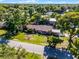 Scenic aerial view of a charming home with a well-manicured lawn and lush trees, near a lake at 1250 Tangerine Ct, Eustis, FL 32726