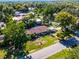 Scenic aerial view of a charming home with a well-manicured lawn and lush trees, near a lake at 1250 Tangerine Ct, Eustis, FL 32726