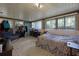 Large bedroom featuring brick wall, carpet flooring, multiple windows, and exterior access at 1250 Tangerine Ct, Eustis, FL 32726