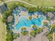 A high angle view shows a large swimming pool with sun loungers, umbrellas, and lush landscaping surrounding the pool at 13293 Pontoon Rd, Winter Garden, FL 34787