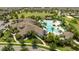 An aerial view showcases a large, resort-style pool, clubhouse, and lush landscaping in the community at 13293 Pontoon Rd, Winter Garden, FL 34787