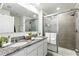Elegant bathroom featuring double sinks, granite countertops, and a glass-enclosed shower at 13293 Pontoon Rd, Winter Garden, FL 34787