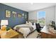Cozy bedroom with a striking accent wall, comfortable furnishings, and a bright workspace at 13293 Pontoon Rd, Winter Garden, FL 34787
