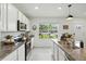 Well-lit kitchen featuring white cabinets, granite countertops, stainless steel appliances, and tile flooring at 13293 Pontoon Rd, Winter Garden, FL 34787