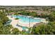 Overhead shot of a beautiful community pool area surrounded by ample deck space and tropical landscaping at 13293 Pontoon Rd, Winter Garden, FL 34787
