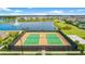 Aerial view of the community tennis courts, sand volleyball court, lake, and lush landscaping at 13293 Pontoon Rd, Winter Garden, FL 34787