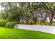 Lush green backyard with a white vinyl fence bordering the property, lined with mature trees and foliage at 1356 Scarlet Oak Loop, Winter Garden, FL 34787