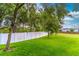 This backyard features a white fence for privacy and landscaping with mature trees shading the yard at 1356 Scarlet Oak Loop, Winter Garden, FL 34787