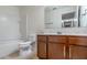 Bathroom featuring wooden cabinets, white countertops, a white toilet and a bathtub with a white tile surround at 1356 Scarlet Oak Loop, Winter Garden, FL 34787
