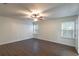 This spacious bedroom features wood-look flooring, a ceiling fan, and bright, natural light from two windows at 1356 Scarlet Oak Loop, Winter Garden, FL 34787