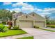 Charming two-story home featuring a three-car garage and well-maintained landscaping under a blue sky at 1356 Scarlet Oak Loop, Winter Garden, FL 34787