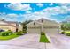 Lovely home showcasing a three-car garage and lush landscaping on a sunny day at 1356 Scarlet Oak Loop, Winter Garden, FL 34787