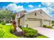 Beautiful two-story home with well-manicured lawn and garden beds leading to a three-car garage at 1356 Scarlet Oak Loop, Winter Garden, FL 34787