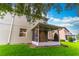 Back exterior view of house with screened-in lanai overlooking lawn and neighboring townhomes at 1356 Scarlet Oak Loop, Winter Garden, FL 34787
