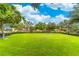 Large grassy community area with mature trees providing shade, offering space for recreation and relaxation at 1356 Scarlet Oak Loop, Winter Garden, FL 34787