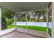 Screened-in lanai showing well-manicured backyard with white vinyl fence and lush trees beyond the property line at 1356 Scarlet Oak Loop, Winter Garden, FL 34787