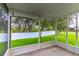 This screened-in lanai overlooks a well-kept backyard with a white fence and mature trees at 1356 Scarlet Oak Loop, Winter Garden, FL 34787