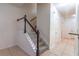 Well-lit staircase with carpeted steps, a dark wood handrail and white balusters lead to the upper level at 1356 Scarlet Oak Loop, Winter Garden, FL 34787