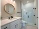 Bathroom with a marble-tiled walk-in shower, white vanity and dark accents at 13617 Haulover Beach Ln, Orlando, FL 32827