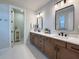 Bathroom showcases double sinks, white countertops, and wood cabinetry with modern black hardware at 13617 Haulover Beach Ln, Orlando, FL 32827