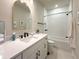 Bathroom featuring a white vanity, gold-trimmed mirror, and a shower-tub combination with white tiled walls at 13617 Haulover Beach Ln, Orlando, FL 32827