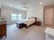 Bedroom includes a bed with white bedding, a wooden chest, and bright windows with neighborhood views at 13617 Haulover Beach Ln, Orlando, FL 32827