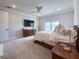 Bedroom featuring neutral walls, wood furniture, white bedding, and bright windows with neighborhood views at 13617 Haulover Beach Ln, Orlando, FL 32827