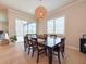 Cozy dining area with a farmhouse-style table, rattan pendant light, and direct access to outdoor living space at 13617 Haulover Beach Ln, Orlando, FL 32827