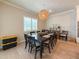 Bright dining room with a large table, stylish chandelier, and natural light streaming through the window at 13617 Haulover Beach Ln, Orlando, FL 32827