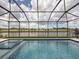 View from inside a screened enclosure overlooking the pool and the beautiful pond that defines the community at 13617 Haulover Beach Ln, Orlando, FL 32827