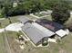 Aerial view displaying the home with detached garage, pool enclosure, and surrounding greenery at 13785 Se 39Th Ter, Summerfield, FL 34491
