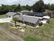 Aerial view of a home with a detached garage, screened-in pool, and well-manicured landscaping at 13785 Se 39Th Ter, Summerfield, FL 34491