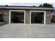 Spacious two-car garage with automatic doors and ample parking space, featuring an outside lighting system at 13785 Se 39Th Ter, Summerfield, FL 34491