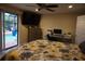 Comfortable main bedroom featuring a ceiling fan, work area, and sliding door access to the outdoor pool at 13785 Se 39Th Ter, Summerfield, FL 34491