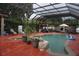 Enclosed pool area with seating, summer kitchen, and decorative waterfall at 13785 Se 39Th Ter, Summerfield, FL 34491