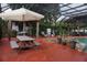 Poolside view with an umbrella-covered picnic table and lounge chairs at 13785 Se 39Th Ter, Summerfield, FL 34491