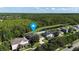 Aerial view featuring a pond, residential homes, and a lush green backdrop, indicating a serene location at 14308 Abington Heights Dr, Orlando, FL 32828