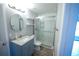 Bathroom with a shower with glass doors, vanity, and a round mirror at 14308 Abington Heights Dr, Orlando, FL 32828