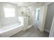 Bright bathroom featuring a tub, shower, and marble surround at 14308 Abington Heights Dr, Orlando, FL 32828