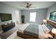 This bedroom features a ceiling fan, television, closet, and sleek, modern furnishings at 14308 Abington Heights Dr, Orlando, FL 32828