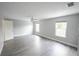 Bright bedroom featuring wood-look floors and two windows at 14308 Abington Heights Dr, Orlando, FL 32828