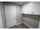 Laundry room with upper cabinets, laminate flooring and utility connections at 14308 Abington Heights Dr, Orlando, FL 32828