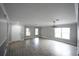 Bright living room with wood floors, large windows, and modern lighting, perfect for entertaining or relaxing at 14308 Abington Heights Dr, Orlando, FL 32828
